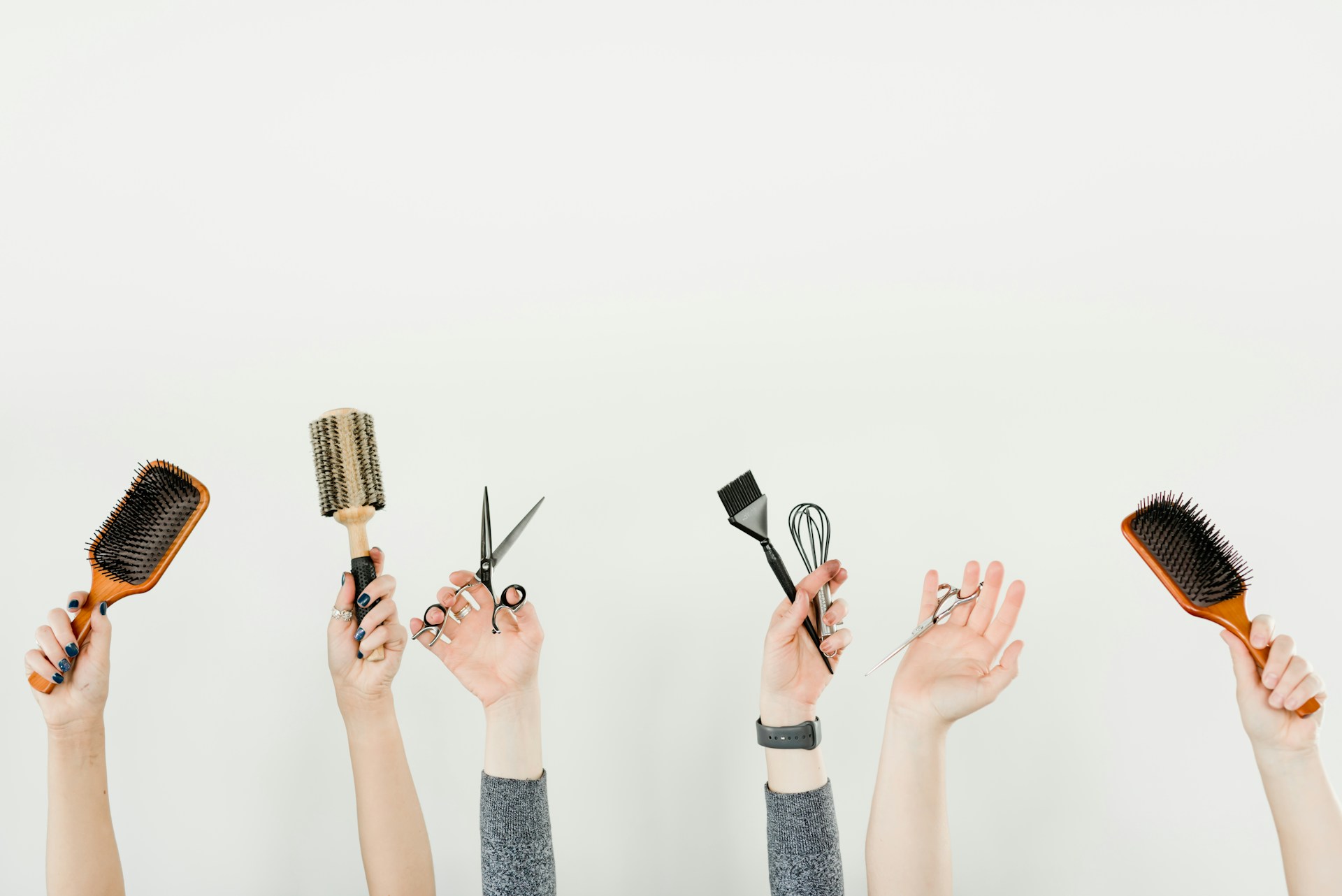 Salon friends with hands in air holding hair tools